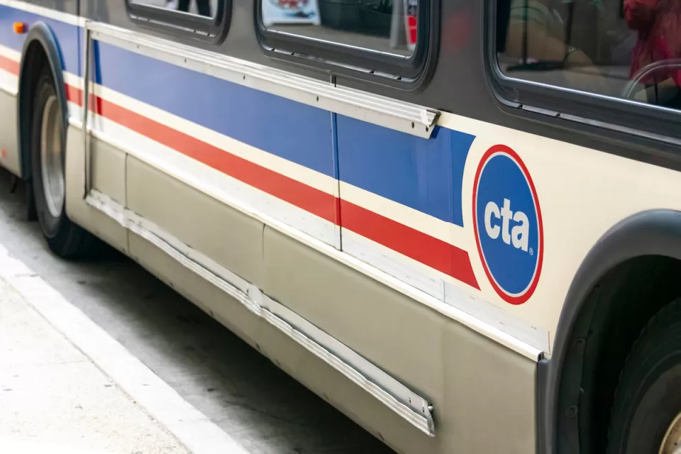 Close-up of side of white and blue and red Chicago Transit Authority bus.